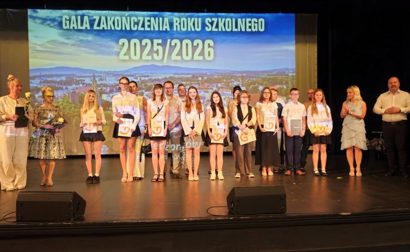 Kilkunastu uczniów z dyplomami na scenie