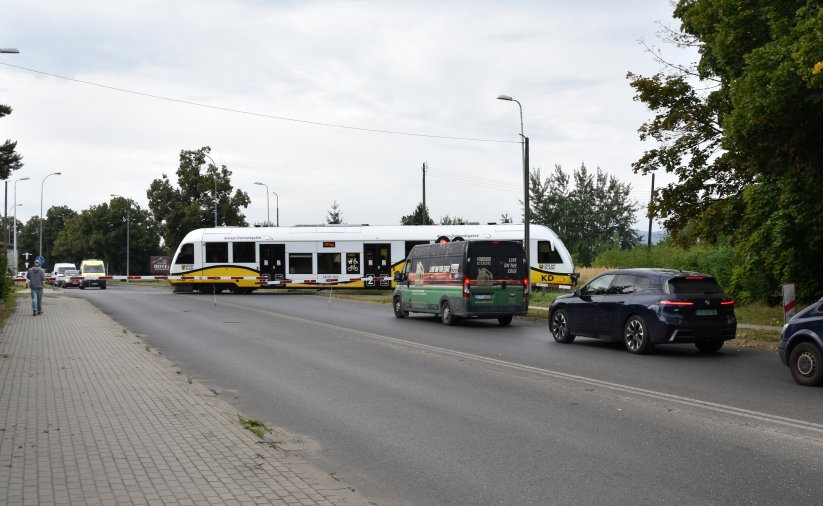 Szynobus przejeżdżający przez przejazd, przed przejazdem samochody 