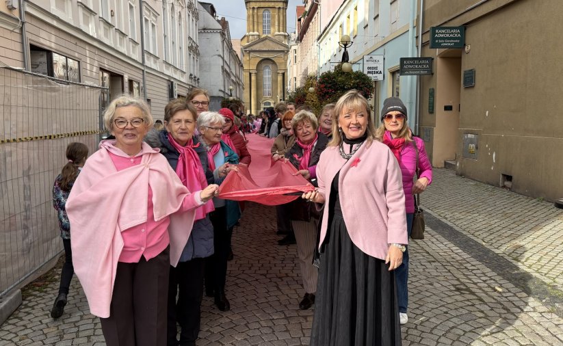 kobiety ubranwe na różowo niosą wielką różową wstęgę