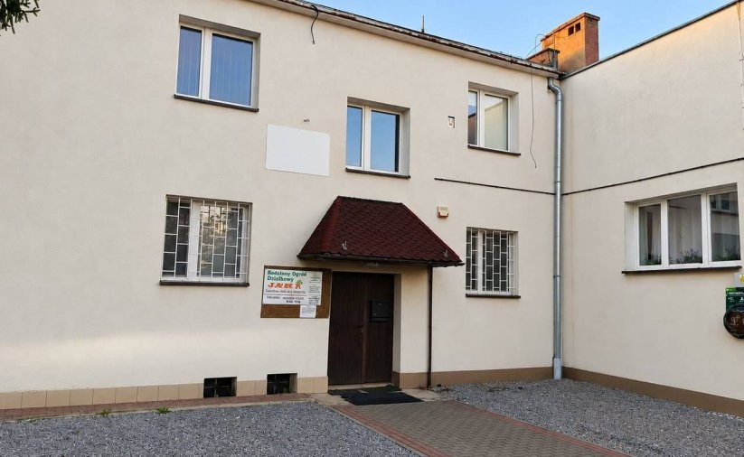 Dwupiętrowy budynek, przy wejściu zamontowany zewnętrzny defibrylator