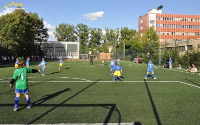 Boisko orlika na którym młodzież gra w piłke nożną, w drugim planie budynek sądu  Dzierżoniowie
