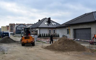 Droga w trakcie budowy, w drugim tle domki jenorodzinne