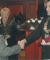 Henryk Ściepuro odbierający medal z rąk przewodniczącego rady