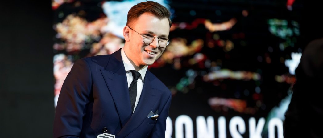 Uśmiechnięty Sławek Gortych w garniturze, ze statuetką w rękach. Fot. Adam Ciereszko