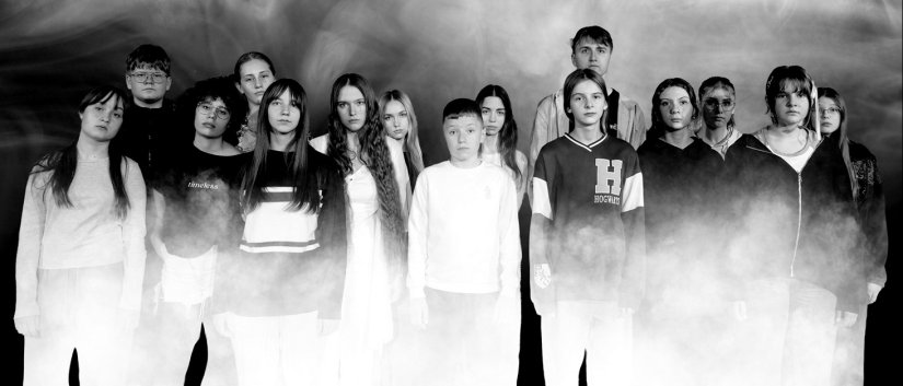 Młodzi aktorzy na wspólnym czarno-białym zdjęciu, za nimi kłębiący się dym