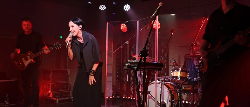 Renata Przemyk śpiewająca na scenie, czerwone światło